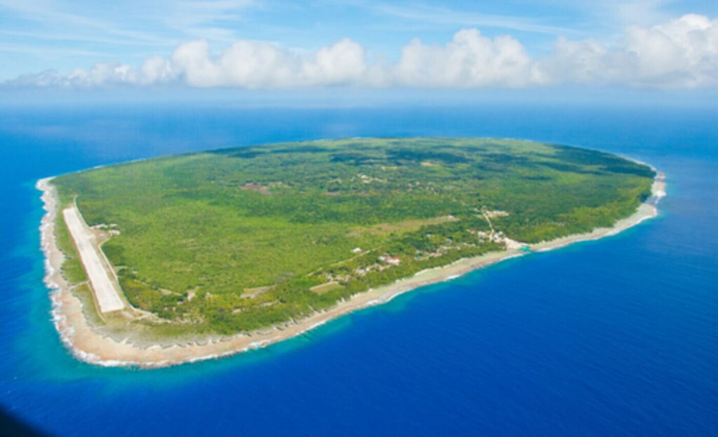 Ma'uke from the air: a green island ringed by reef and open ocean.
